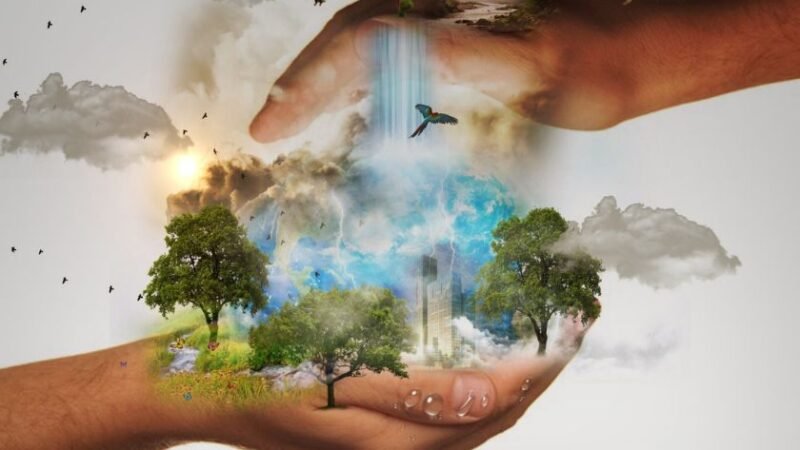 Mains humaines protégeant une planète miniature avec arbres, cascades, oiseaux et nuages.