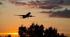 Avion de ligne décollant au coucher du soleil.