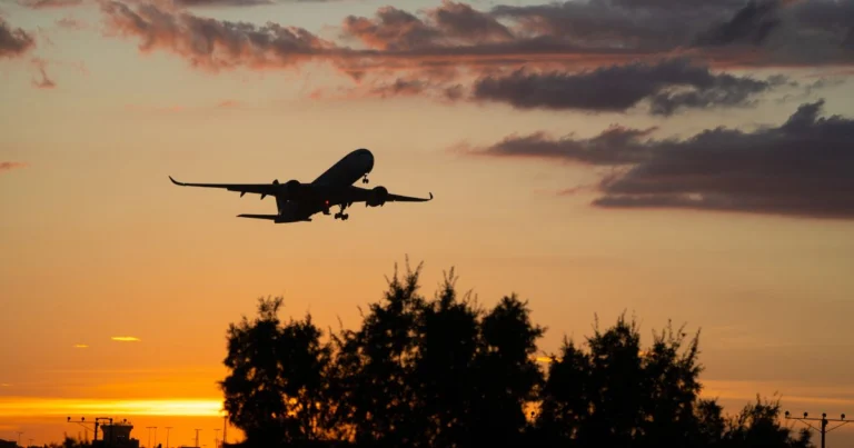 Avion de ligne décollant au coucher du soleil.